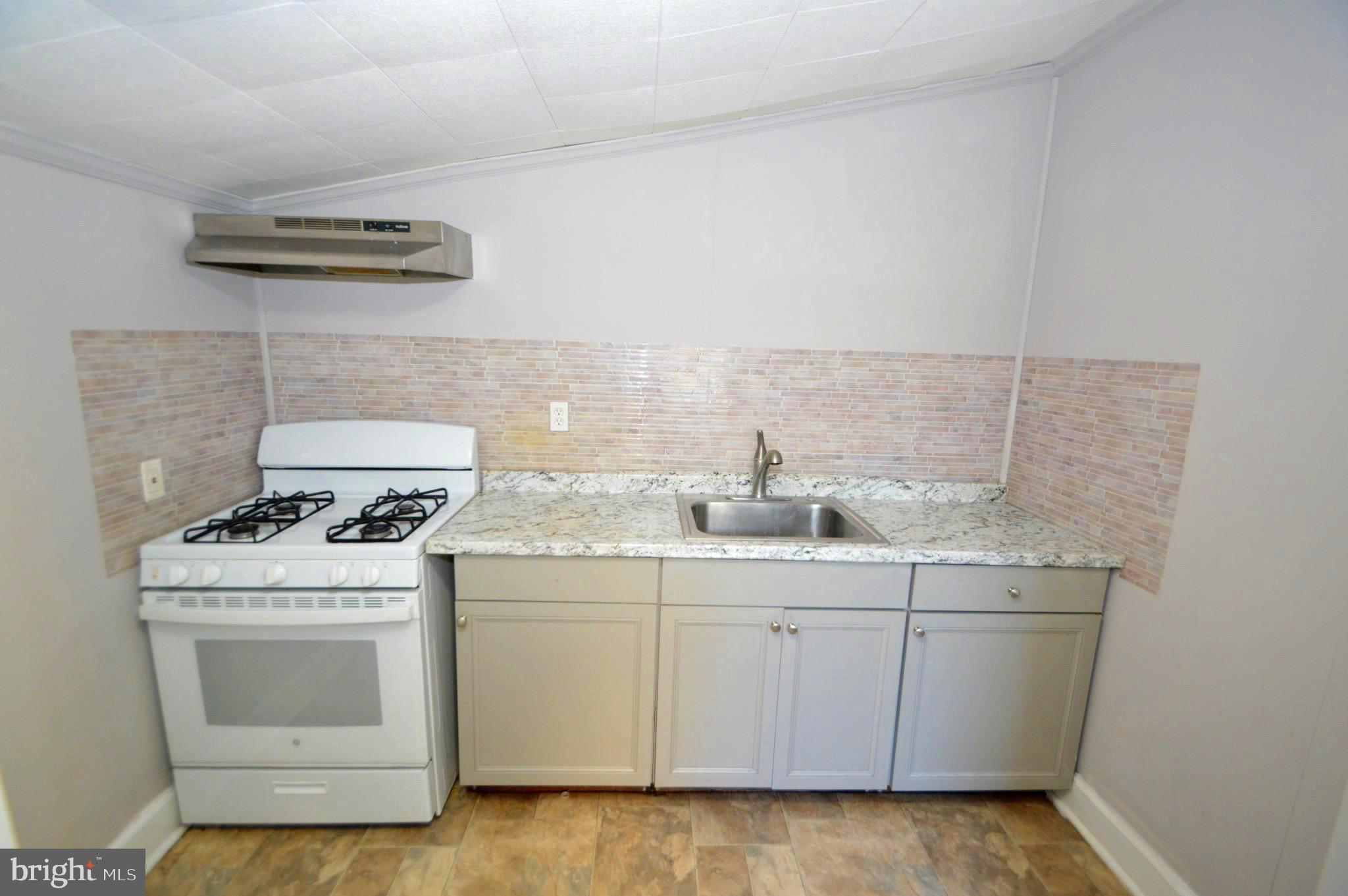 348 Barclay Street Burlington, NJ 08016 - Photo 7 of 21 a kitchen with a sink stove and cabinets