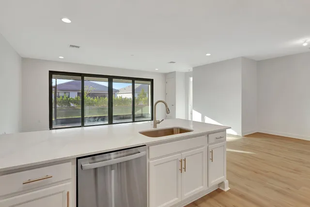 a kitchen with granite countertop white cabinets and stainless steel appliances