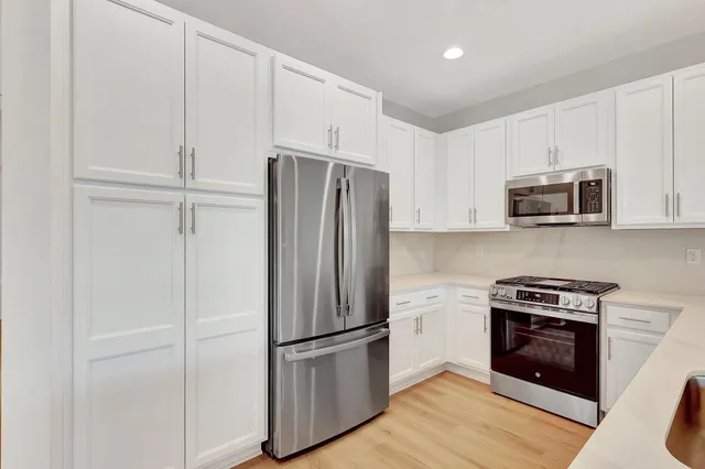a view of a kitchen with a sink and a refrigerator