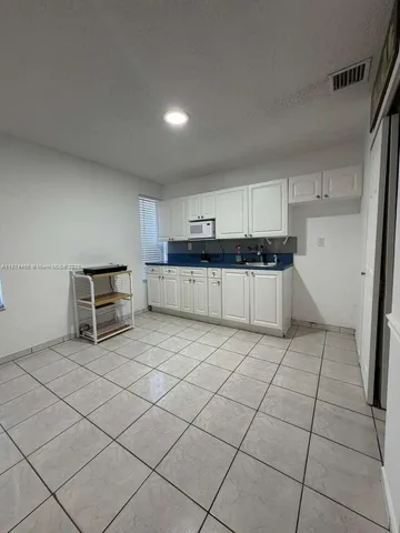 a kitchen with granite countertop a sink and cabinets