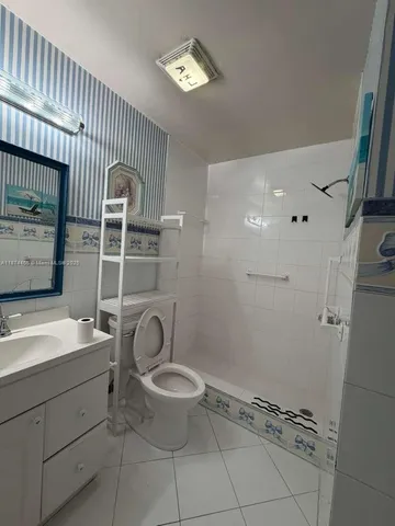 a spacious bathroom with a toilet a sink and mirror