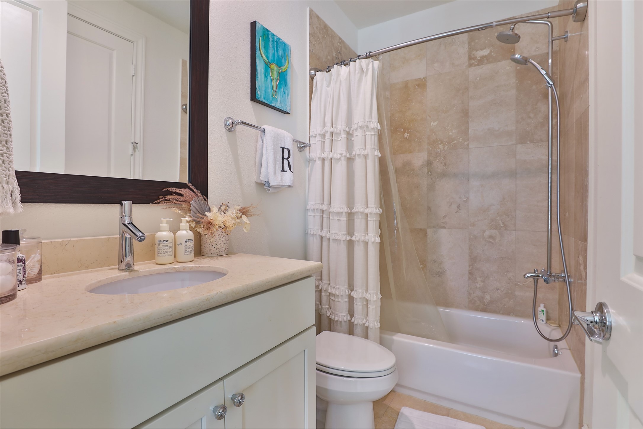 2303 Kolbe Run Lane Houston, TX 77080 - Photo 9 of 35 This elegant ensuite bathroom features timeless travertine-look tiles complemented by classic shaker cabinetry, creating a perfect blend of luxury and style.