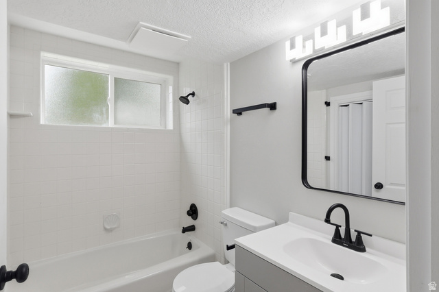 629 King Circle Layton, UT 84041 - Photo 19 of 26 Bathroom featuring a white subway tile tub surround, black fixtures, and a vanity with a white countertop and integrated sink