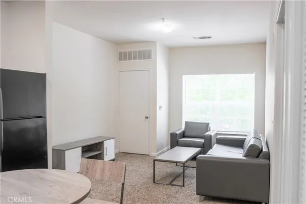 a living room with furniture and a floor to ceiling window