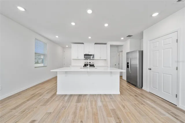 a view living room with wooden floors and kitchen view