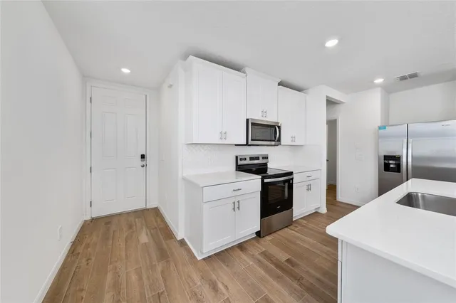 a kitchen with a refrigerator a stove top oven a sink and dishwasher
