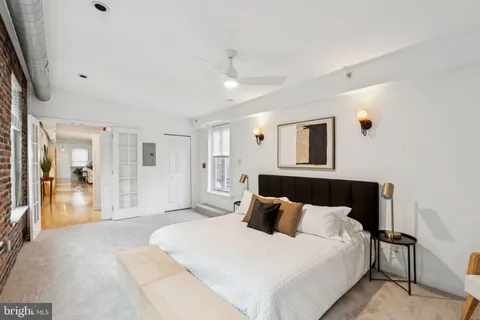 a spacious bedroom with a large bed and a chandelier