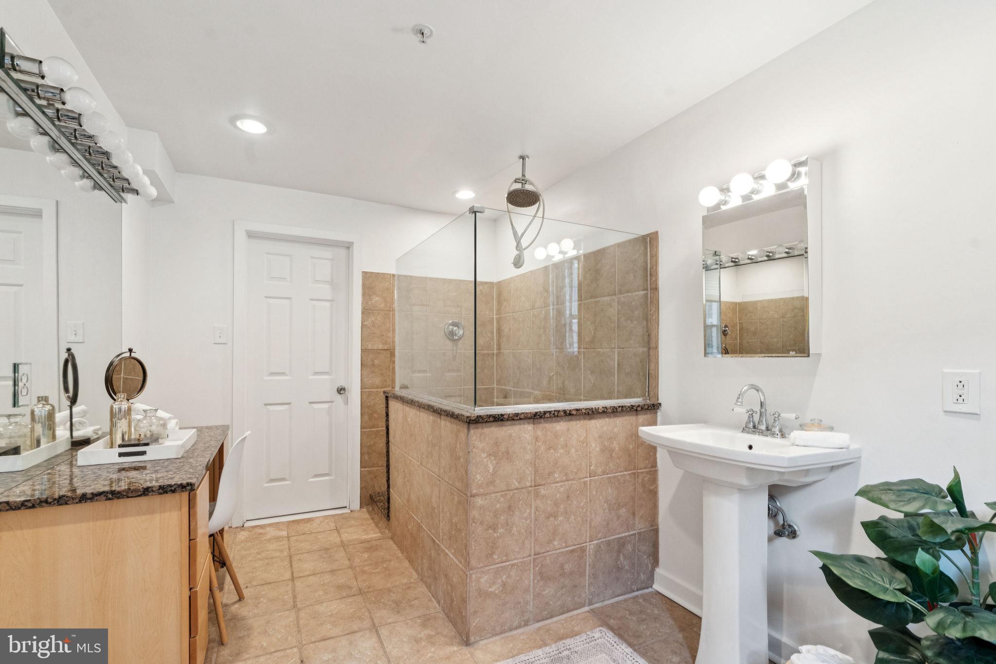 1246 East Montgomery Avenue, Unit 5 Philadelphia, PA 19125 - Photo 12 of 18 a bathroom with a sink a mirror and a shower