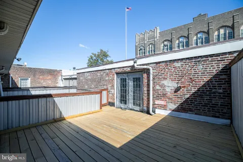 a view of a wooden chairs on the roof deck