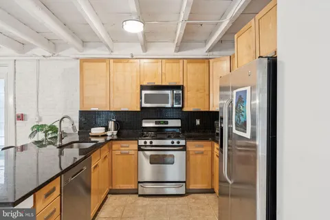 a kitchen with appliances a sink and cabinets