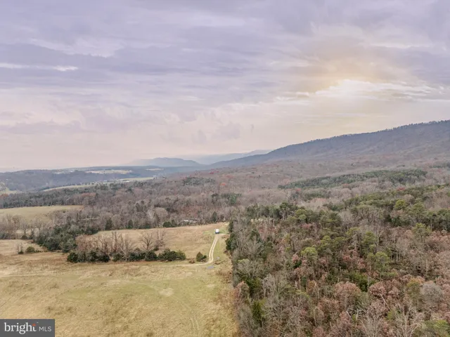 a view of a dry yard with mountains in the background