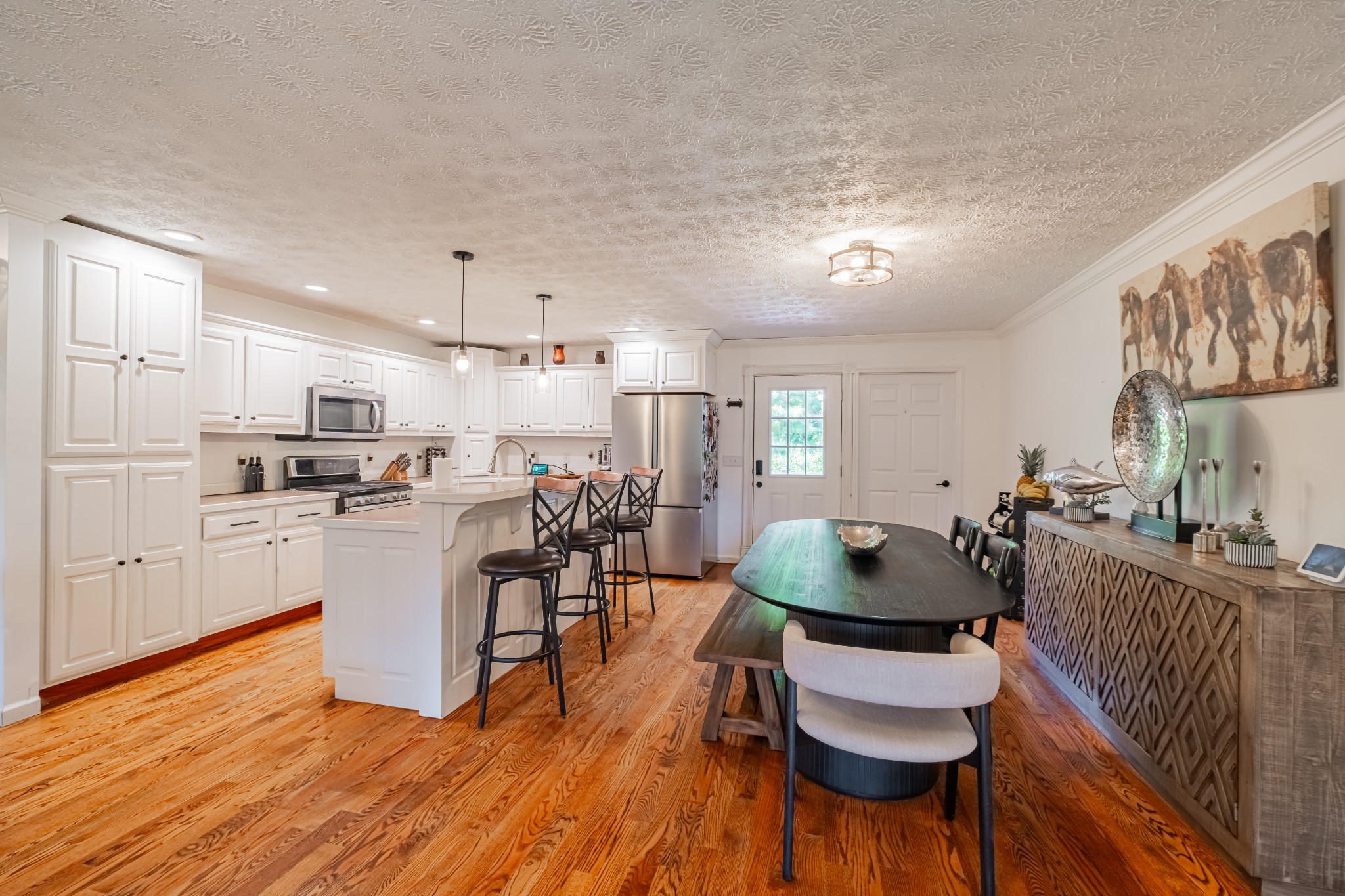 1450 Pleasant Hill Road McMinnville, TN 37110 - Photo 14 of 68 a kitchen with stainless steel appliances granite countertop a stove a refrigerator a kitchen island a dining table and chairs with wooden floor