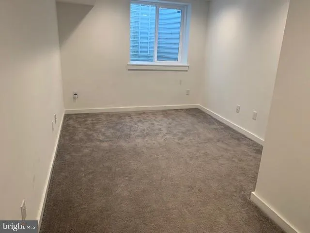 a view of a hallway with wooden floor and a bathroom