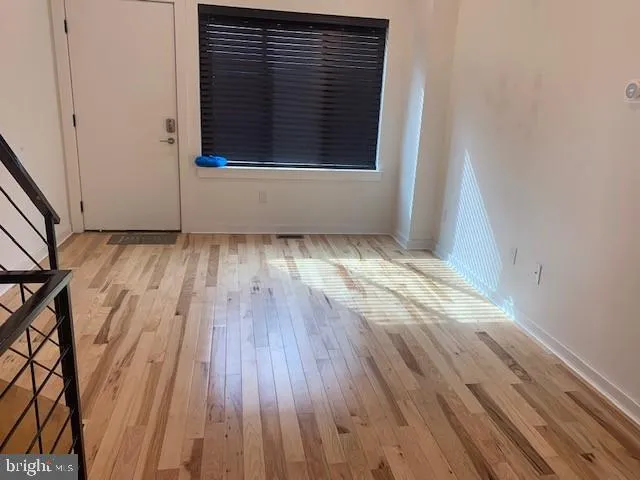 a view of a room with wooden floor and window