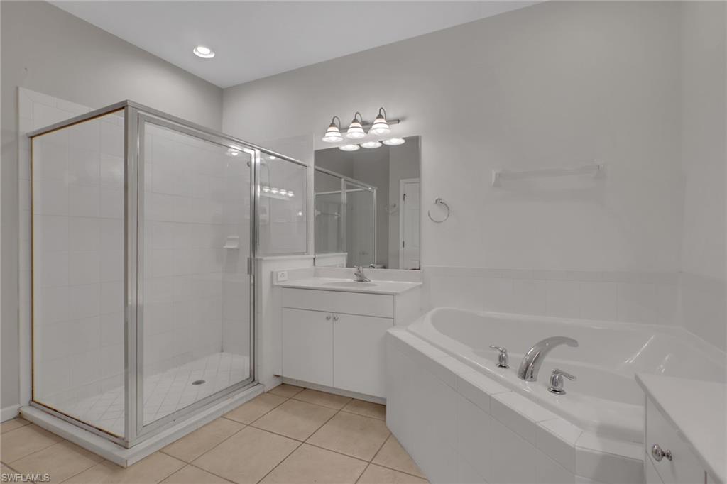 7844 Clemson Street, Unit 102 Naples, FL 34104 - Photo 17 of 31 a bathroom with a tub shower vanity and a sink