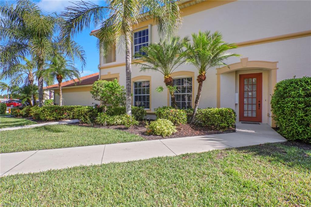 7844 Clemson Street, Unit 102 Naples, FL 34104 - Photo 2 of 31 a front view of a house with a yard