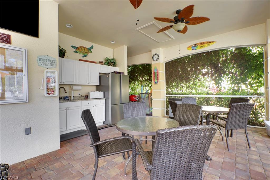 7844 Clemson Street, Unit 102 Naples, FL 34104 - Photo 27 of 31 a dining room with furniture a floor to ceiling window and a flat screen tv
