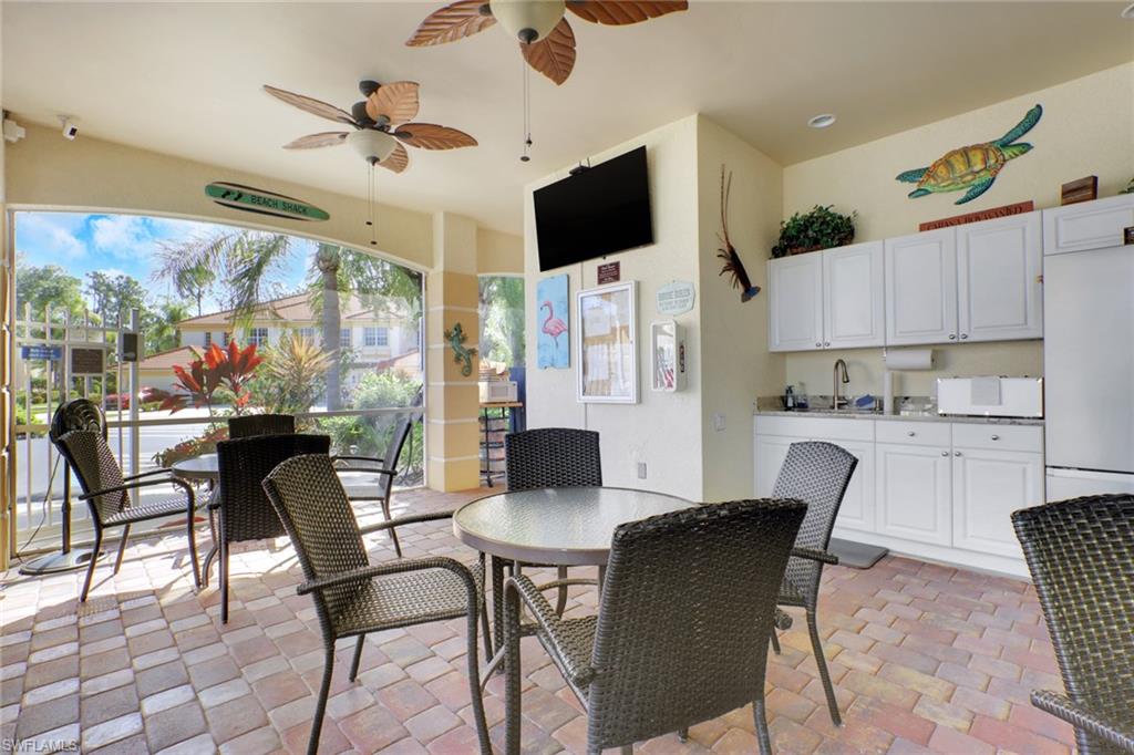 7844 Clemson Street, Unit 102 Naples, FL 34104 - Photo 28 of 31 a dining room with furniture and a flat screen tv