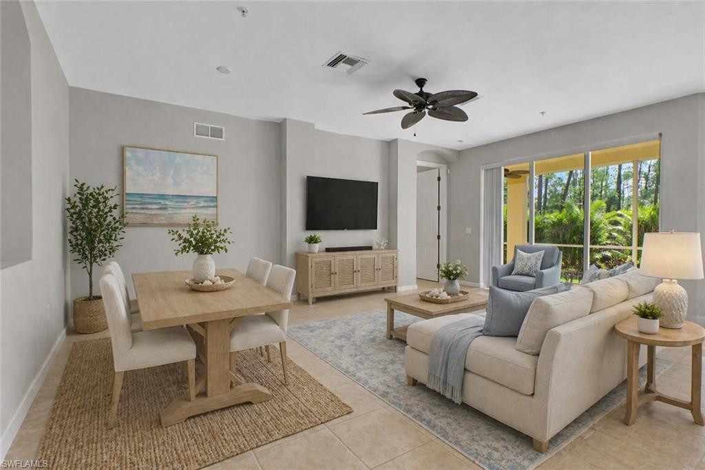 7844 Clemson Street, Unit 102 Naples, FL 34104 - Photo 3 of 31 a living room with furniture a flat screen tv and a large window