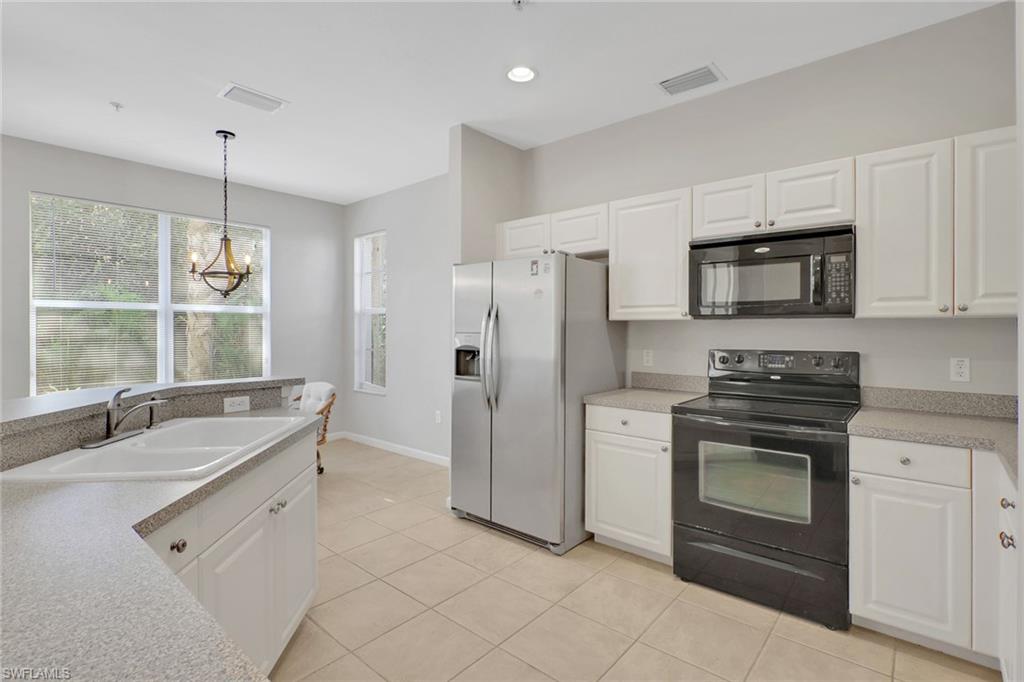 7844 Clemson Street, Unit 102 Naples, FL 34104 - Photo 9 of 31 a kitchen with stainless steel appliances granite countertop a stove a refrigerator and a sink