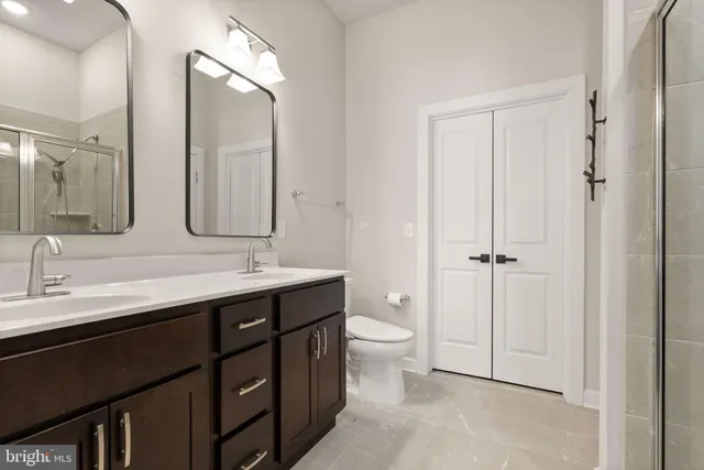 a bathroom with a double vanity sink mirror and toilet