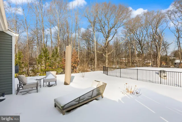 a view of backyard with large trees and wooden fence