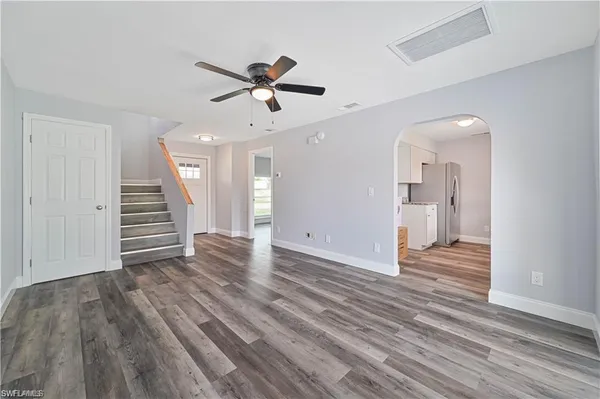 a view of a livingroom with wooden floor and a ceiling fan