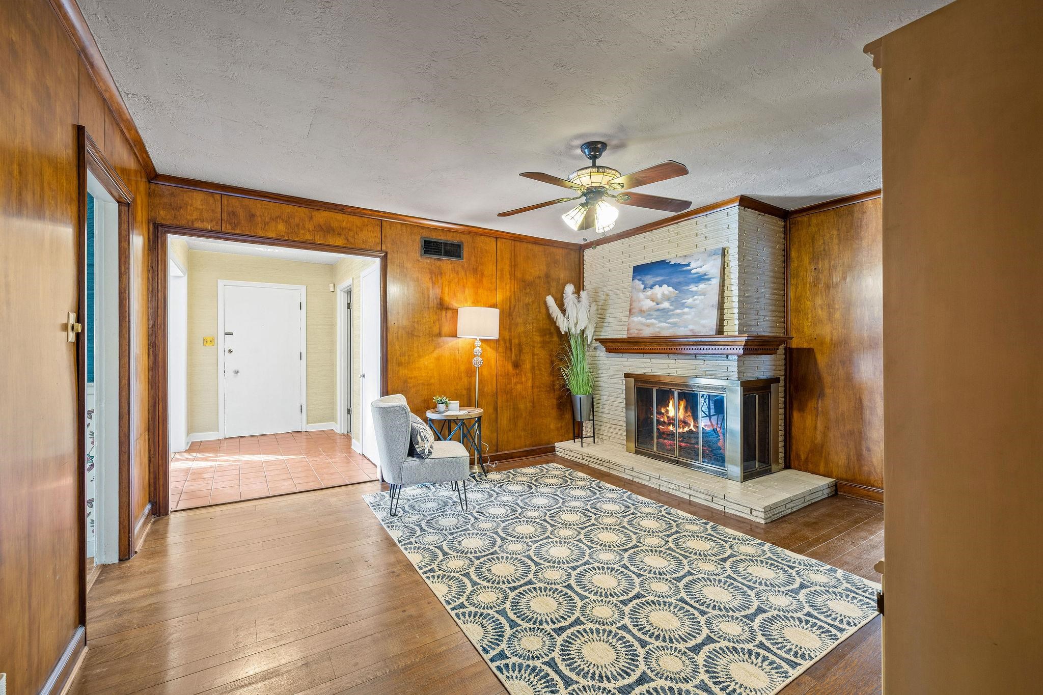 1002 Kings Park Road Memphis, TN 38117 - Photo 23 of 40 a living room with furniture a fireplace and a chandelier