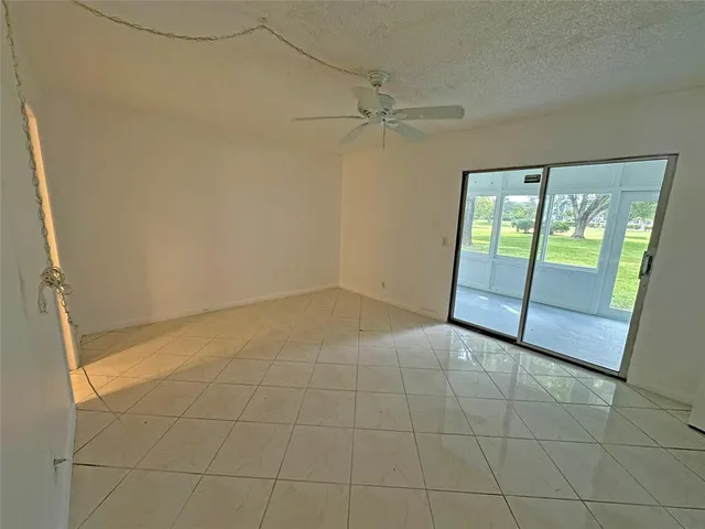 a view of a big room with windows and chandelier fan