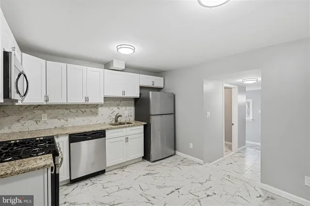a kitchen with a stove a refrigerator and cabinets