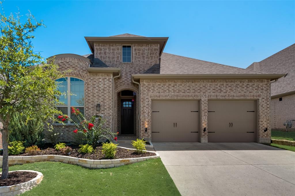 3916 Ironbark Way McKinney, TX 75071 - Photo 2 of 23 a front view of a house with a garden and plants