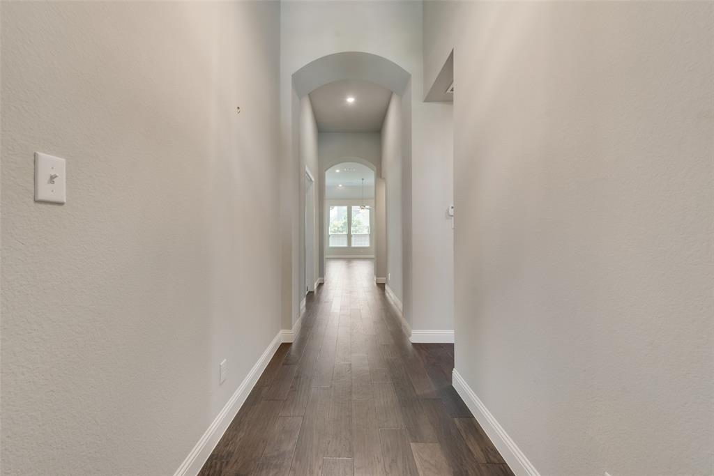 3916 Ironbark Way McKinney, TX 75071 - Photo 3 of 23 a view of a hallway with wooden floor