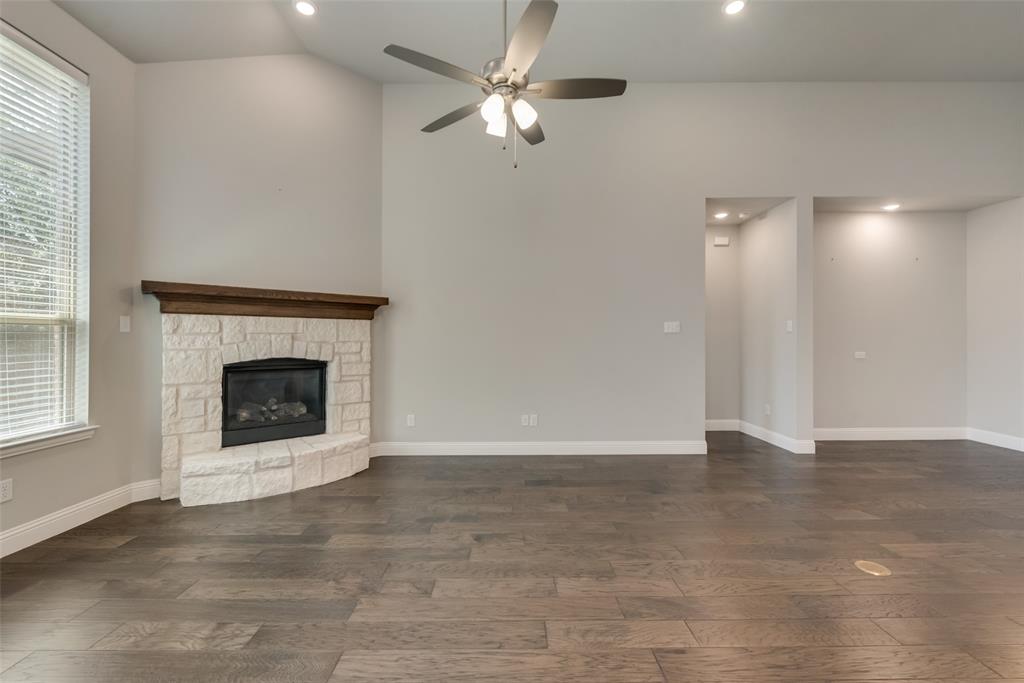 3916 Ironbark Way McKinney, TX 75071 - Photo 7 of 23 a view of an empty room with chandelier fan and fire place