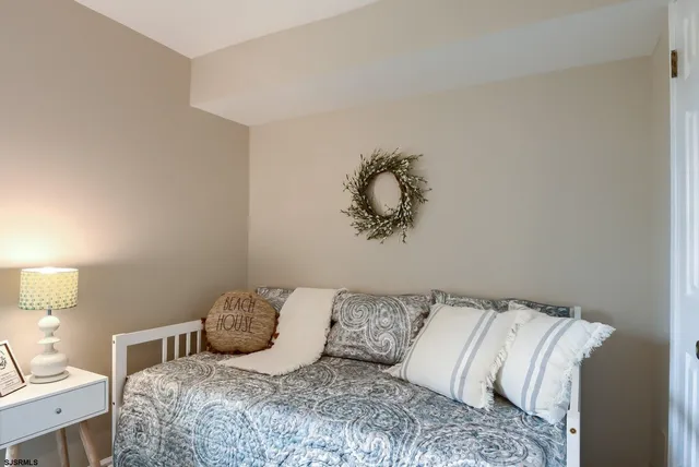 a bedroom with a large bed and a lamp with the dresser