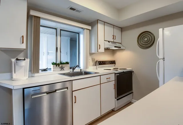 a kitchen with stainless steel appliances a sink and a refrigerator