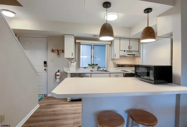 a kitchen with a sink a stove and chairs