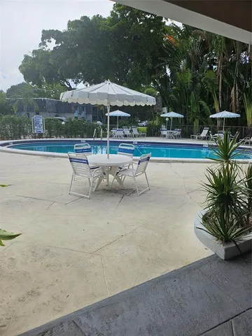 a living room with patio furniture and a large window