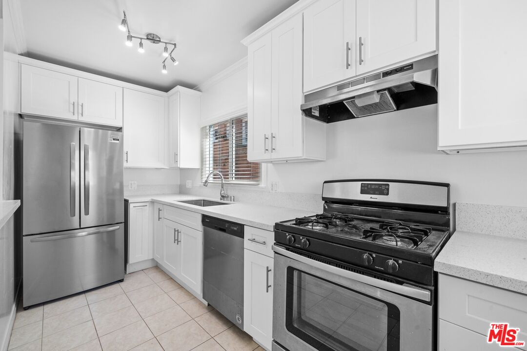 38 20th Avenue, Unit C Venice, CA 90291 - Photo 3 of 10 a kitchen with stainless steel appliances a stove a microwave and a refrigerator