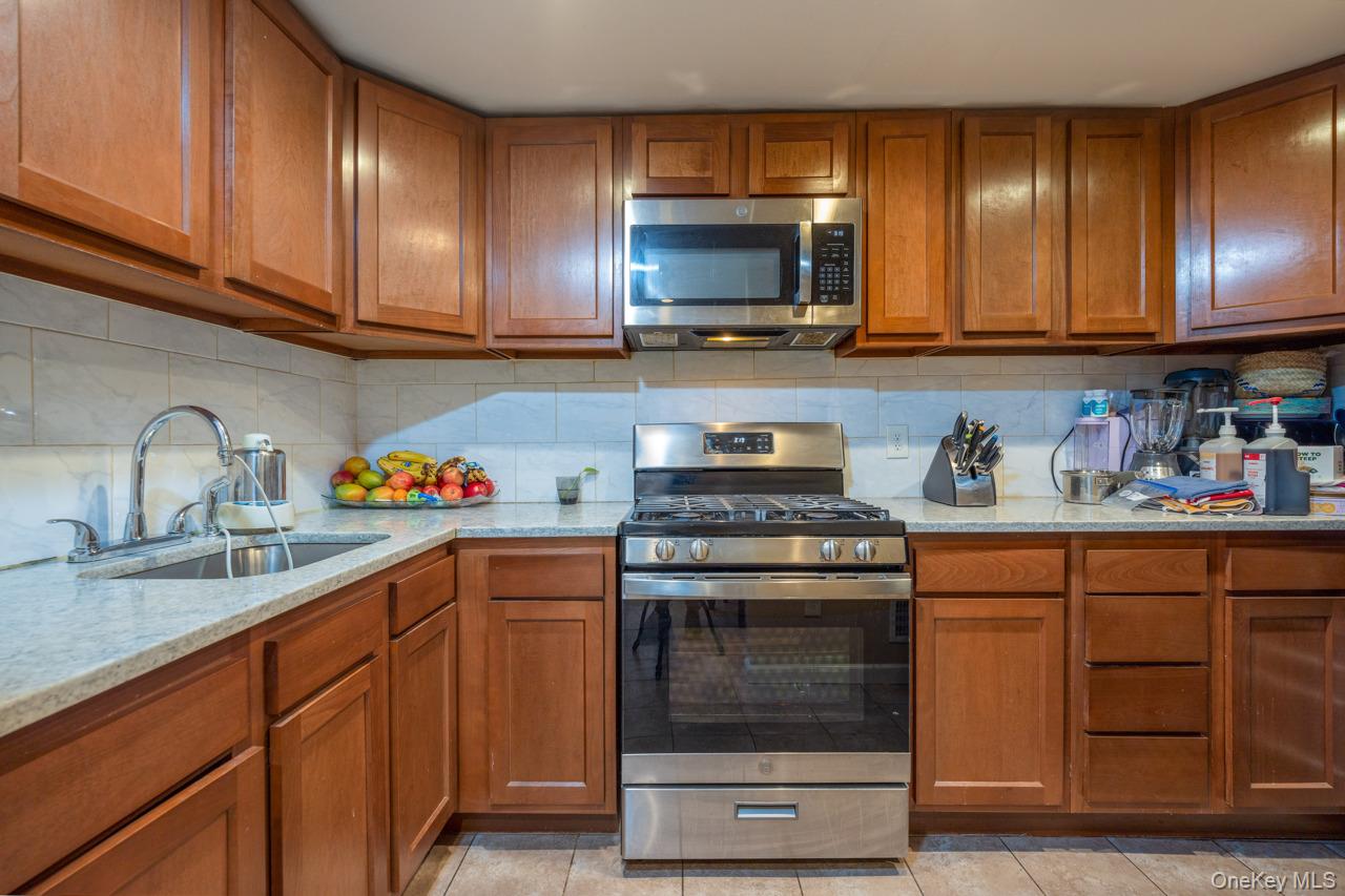 280 1st Street Newburgh, NY 12550 - Photo 11 of 24 a kitchen with granite countertop wooden cabinets and a stove top oven