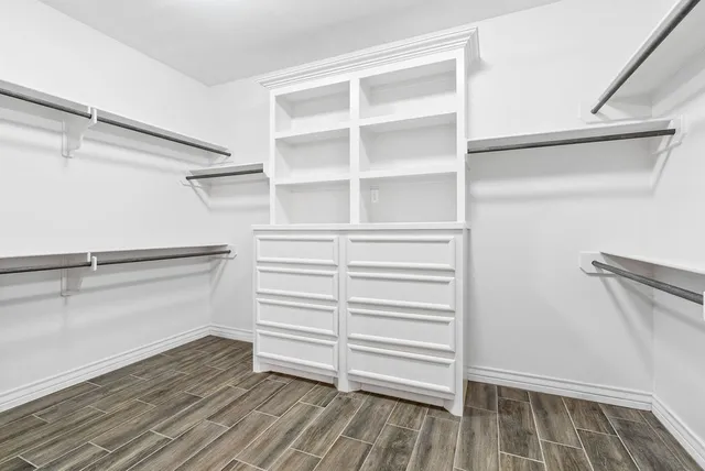 a view of walk in closet with empty racks