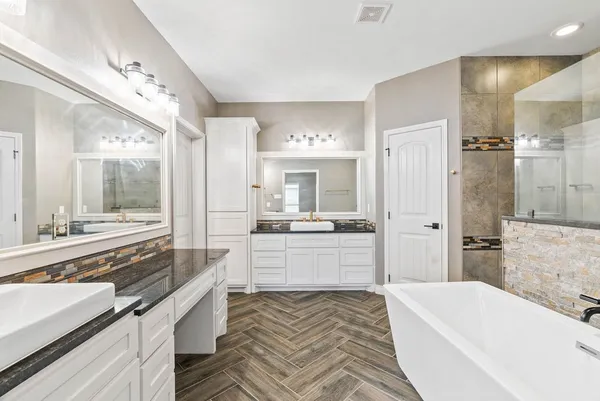 a large spacious bathroom with a large tub shower and sink