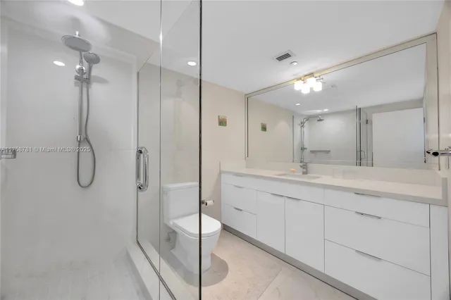 a bathroom with a double vanity sink mirror and shower