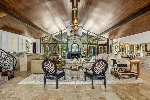 a living room with furniture a fireplace and a large window