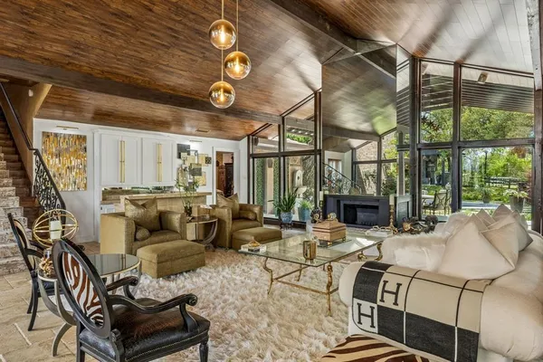 a living room with fireplace furniture and a large window