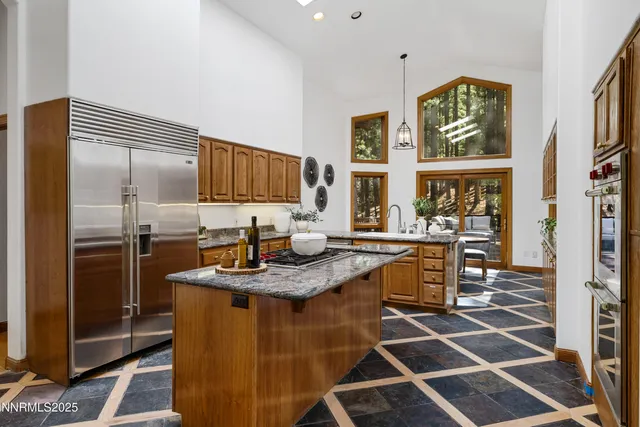 a kitchen with sink granite counter and a large window