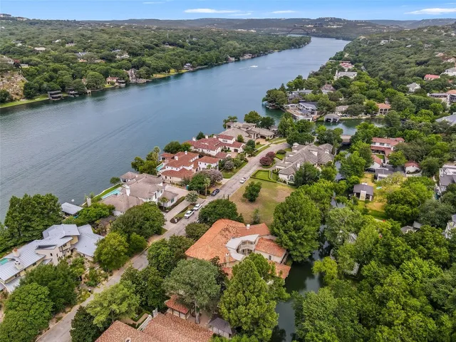 an aerial view of lake residential house with swimming pool and mountain view