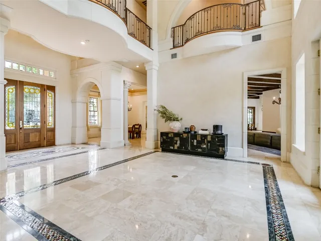 a view of a hallway with a livingroom with furniture and a ceiling fan