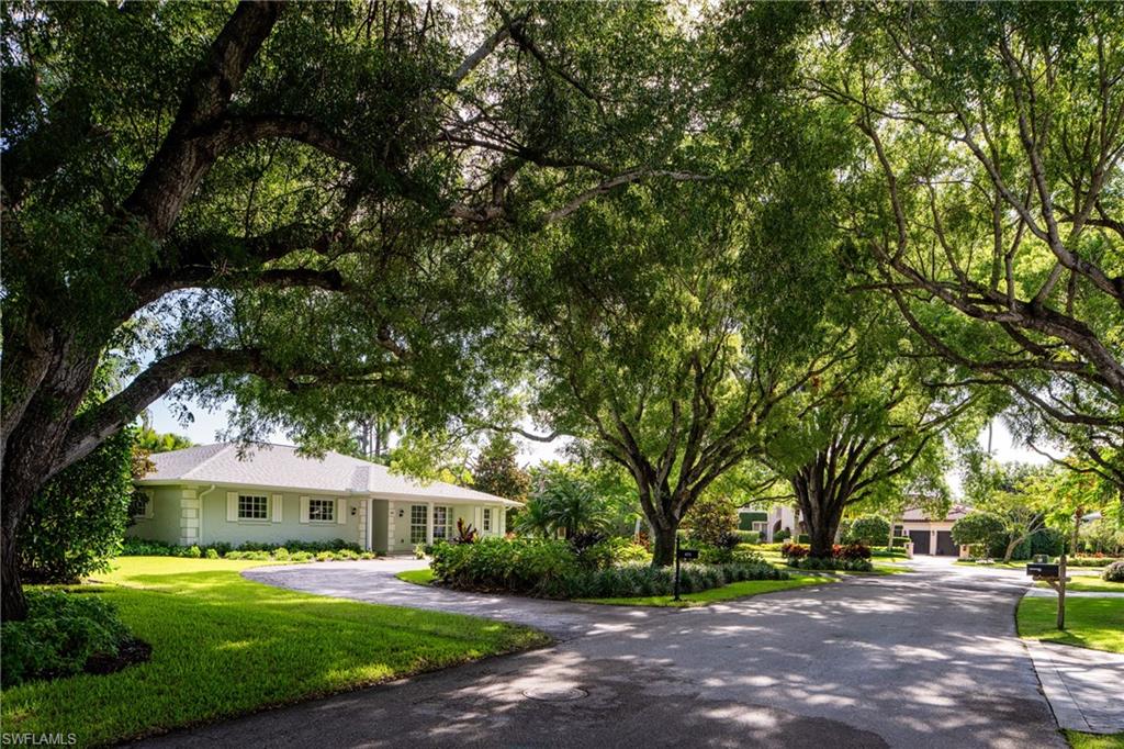 675 Yucca Road Naples, FL 34102 - Photo 22 of 24 a view of house with a big yard and large trees
