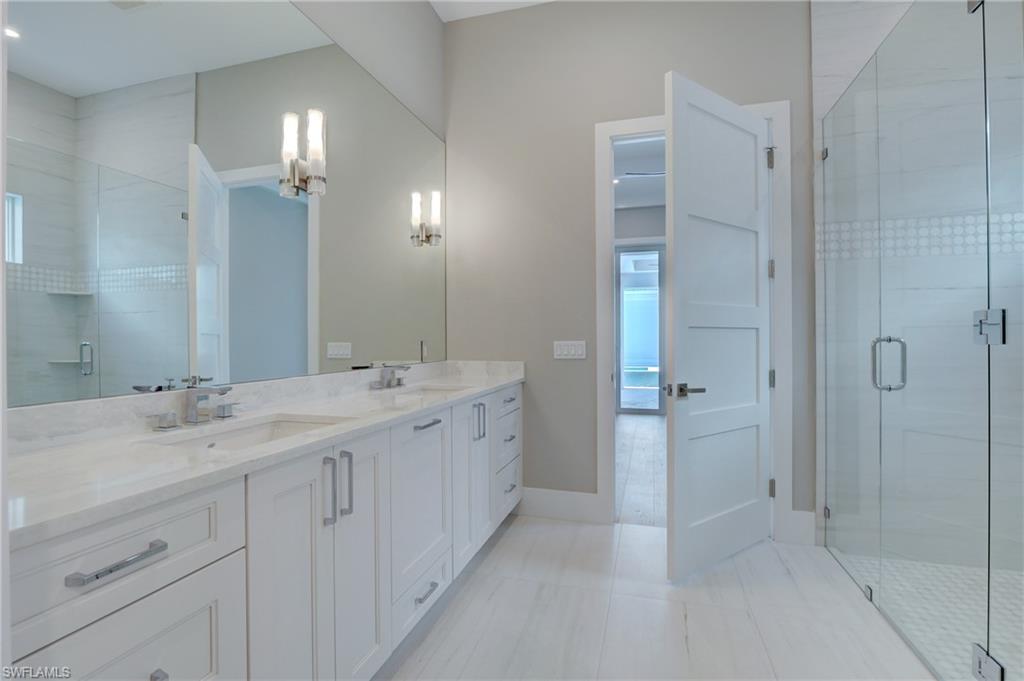 888 10th Avenue South Naples, FL 34102 - Photo 11 of 30 a bathroom with a double vanity sink and mirror