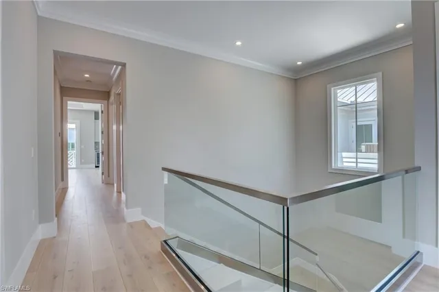 a view of a hallway with wooden floor and staircase